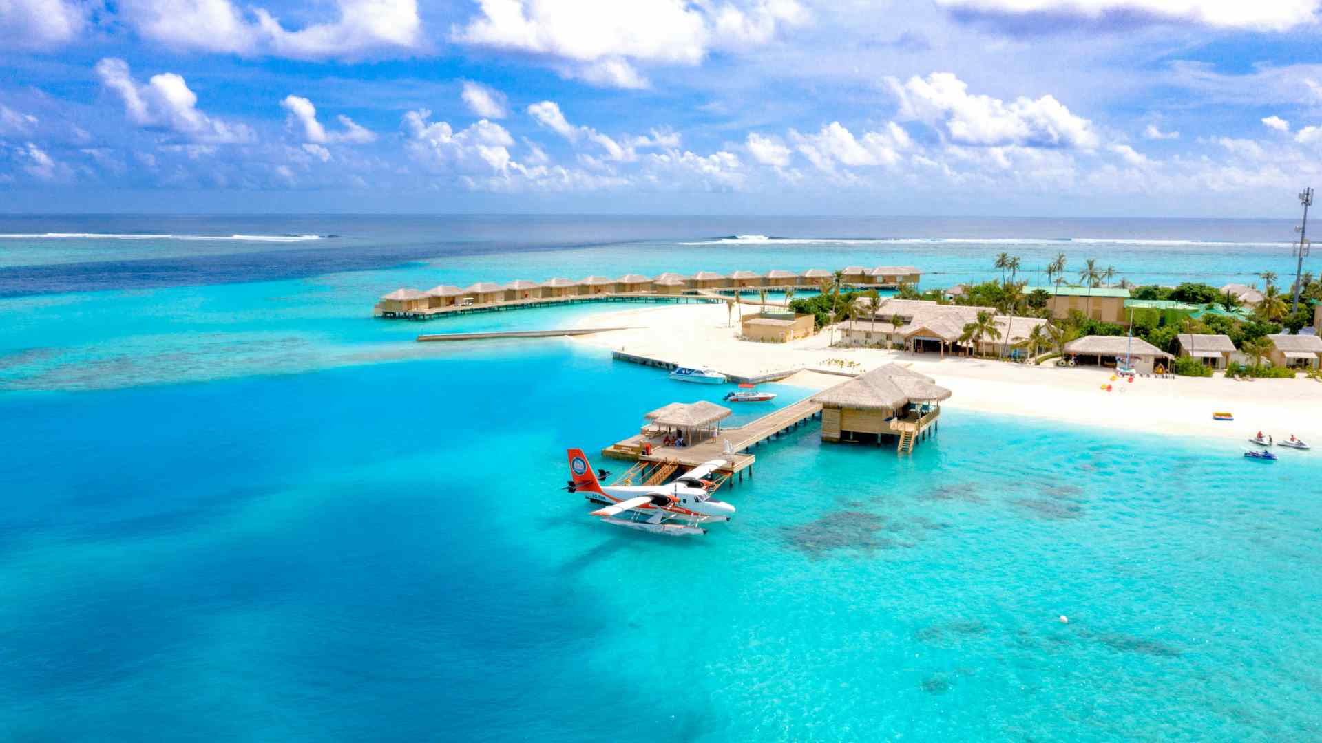 Thatched overwater buildings connected by a wooden walkway