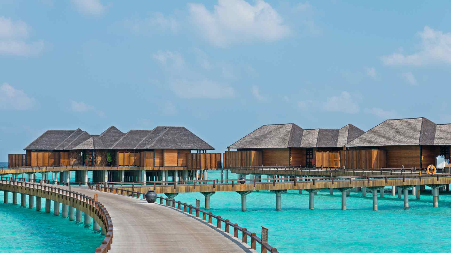 Thatched water villas over a sheltered Mexican lagoon on an overcast shoulder season afternoon
