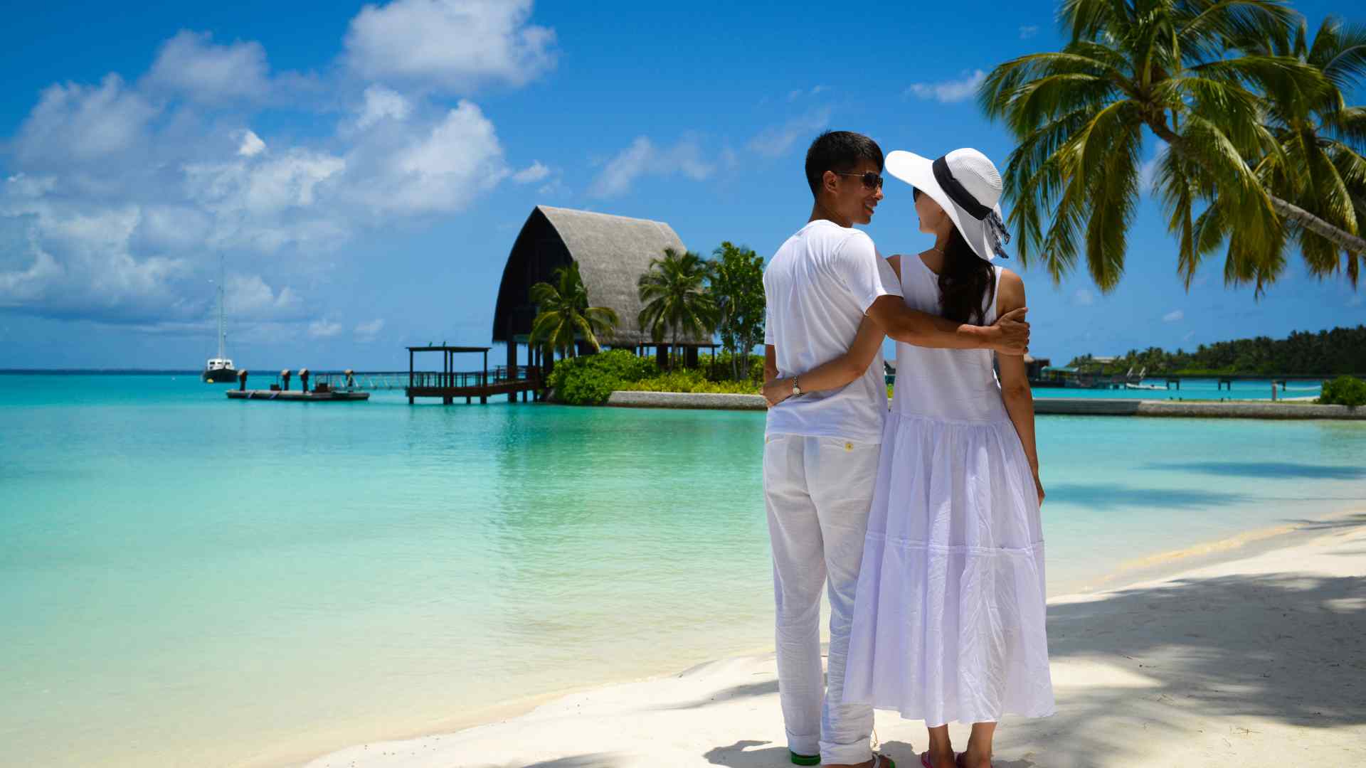 Couple beside tropical overwater bungalows