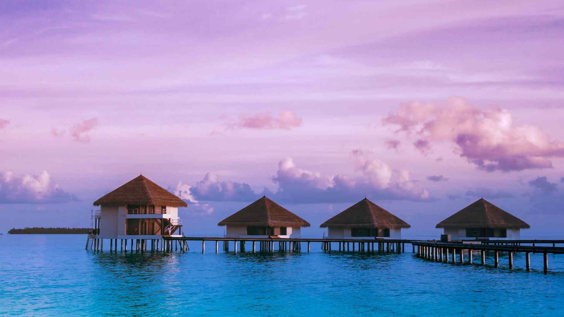 Overwater bungalows above a clear tropical lagoon