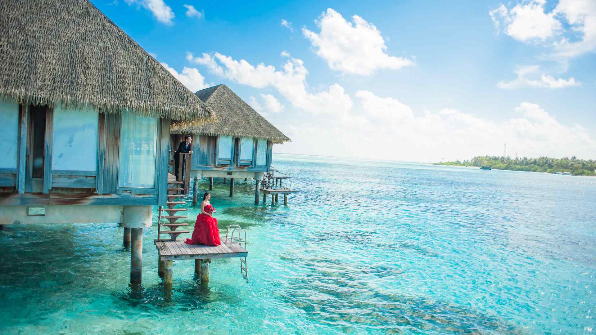 Couple relaxing on the deck of a private overwater bungalow