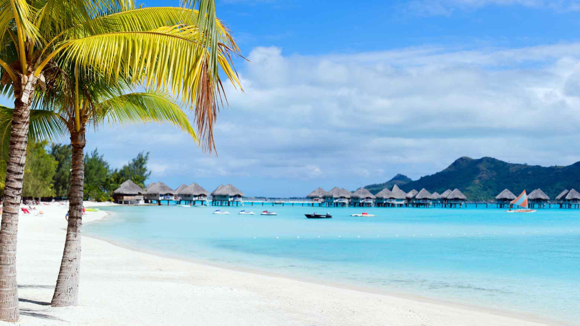 Tropical overwater bungalows above clear blue water