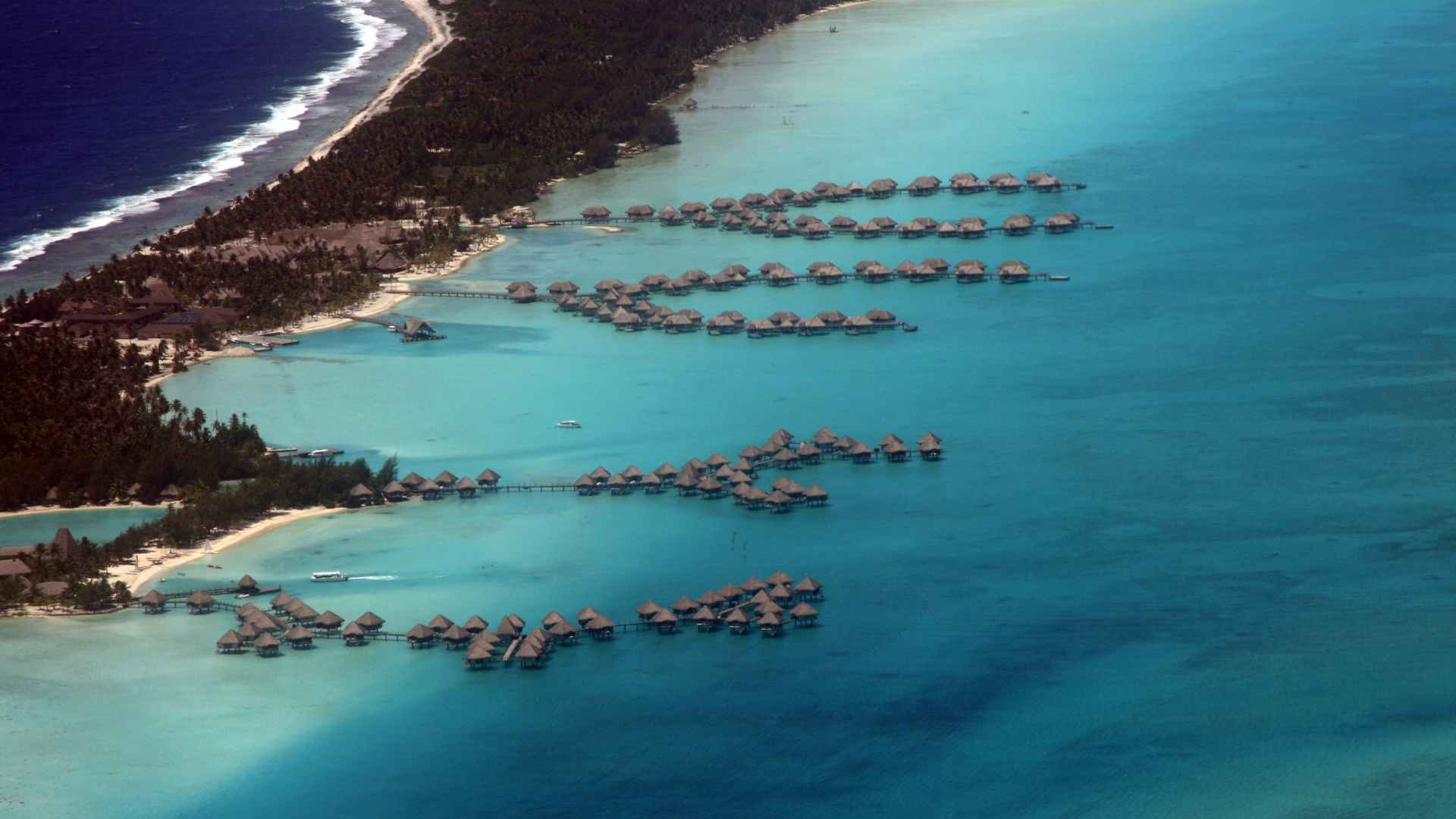 Two-story Sandals overwater villas in a green Caribbean cove