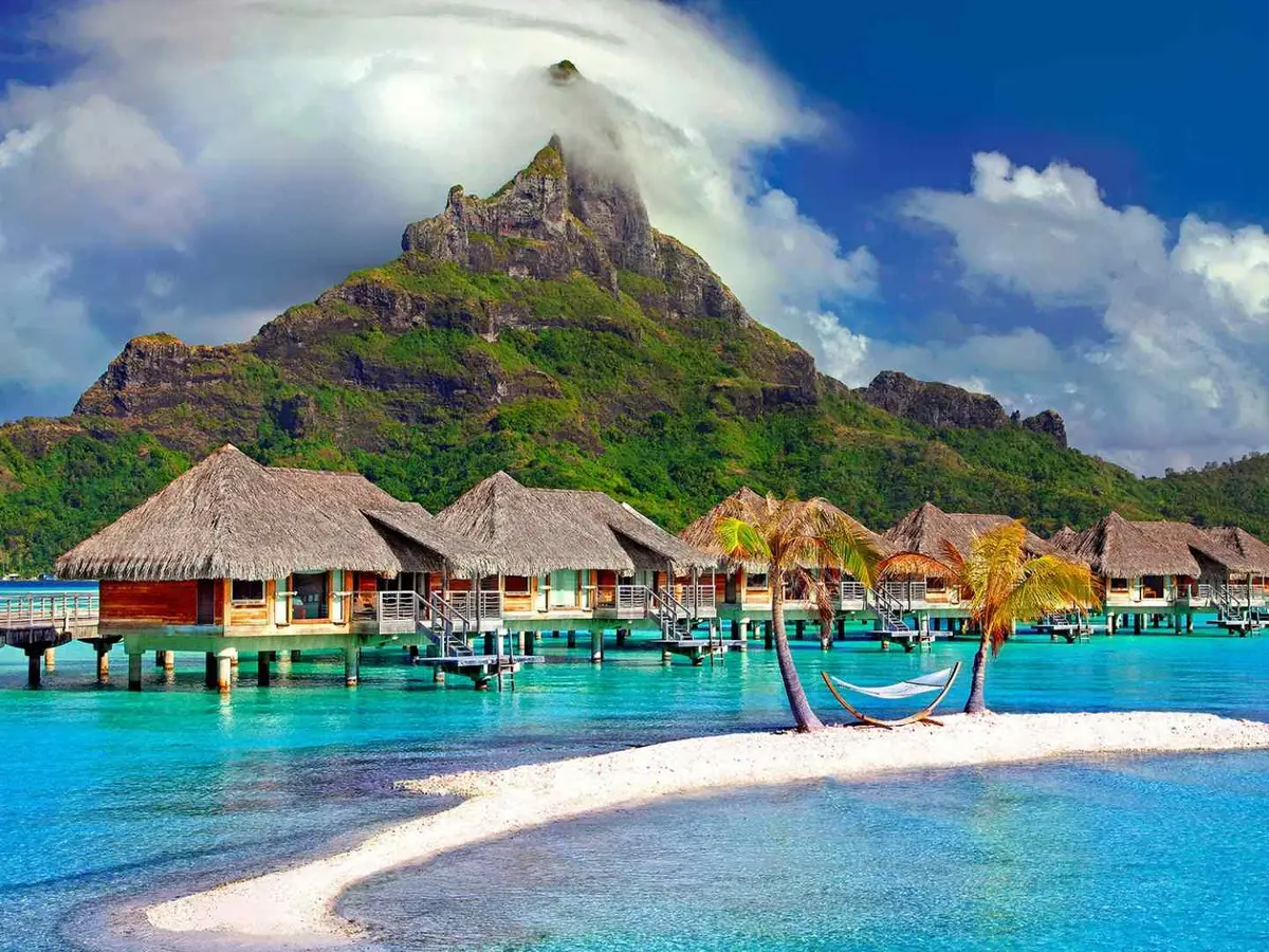 Thatched water villas extending above calm blue water