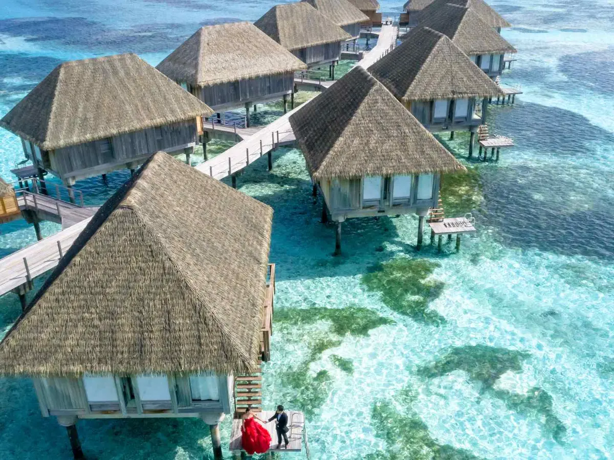 A boardwalk leading to tropical overwater bungalows